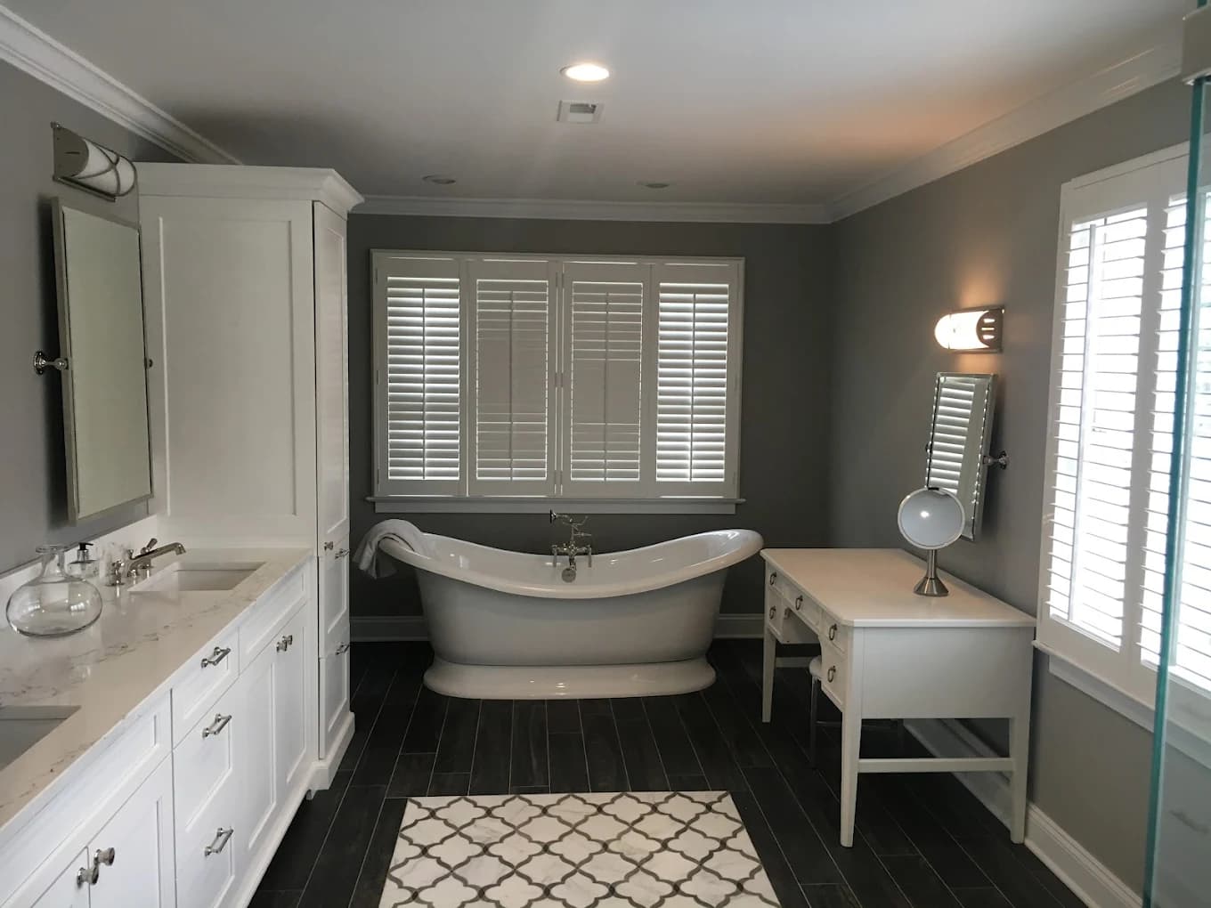 Renovated bathroom with painted walls, custom vanity, and freestanding tub.